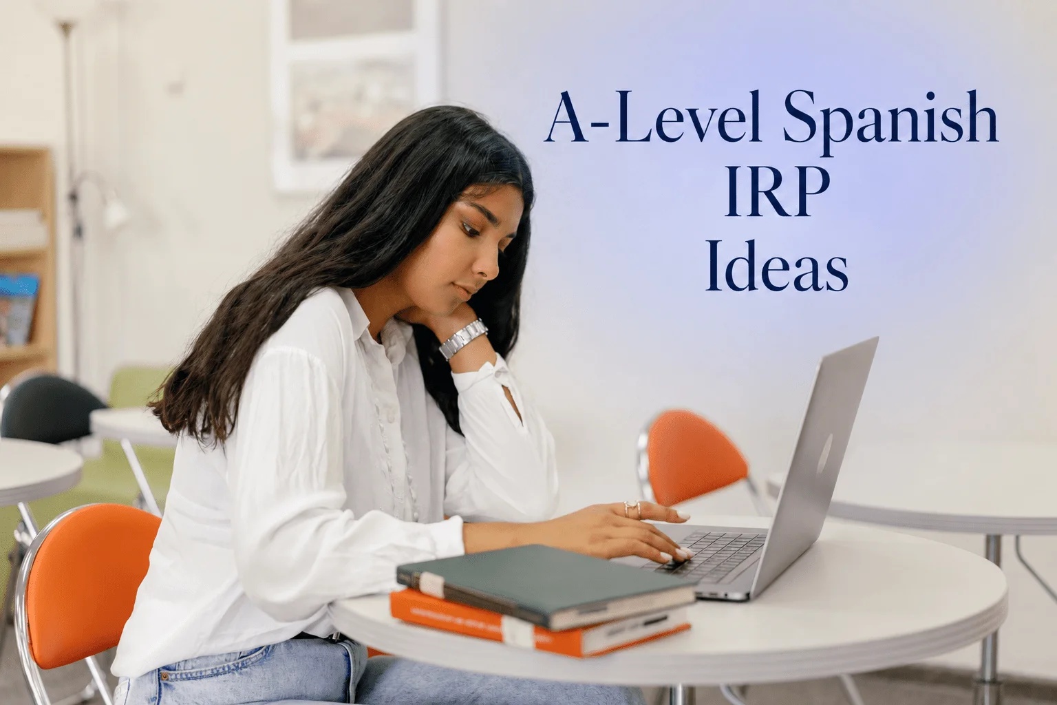 Student researching A-Level Spanish IRP ideas using a laptop and notebook